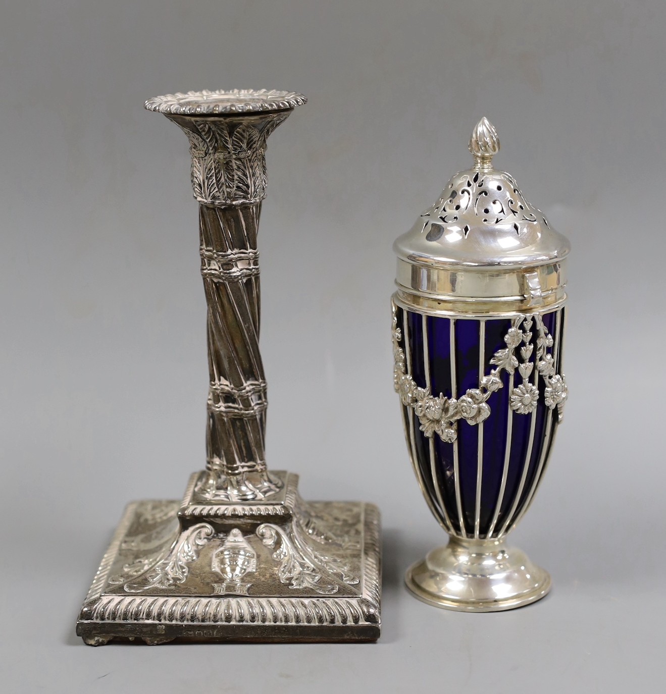 An Edwardian pierced silver sifter, with blue glass liner, Haseler Brothers, London, 1904, 17.3cm and a single Victorian silver candlestick, weighted.